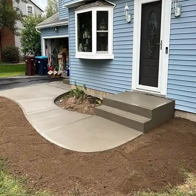 Newly installed concrete walkway and steps leading to a home's front door